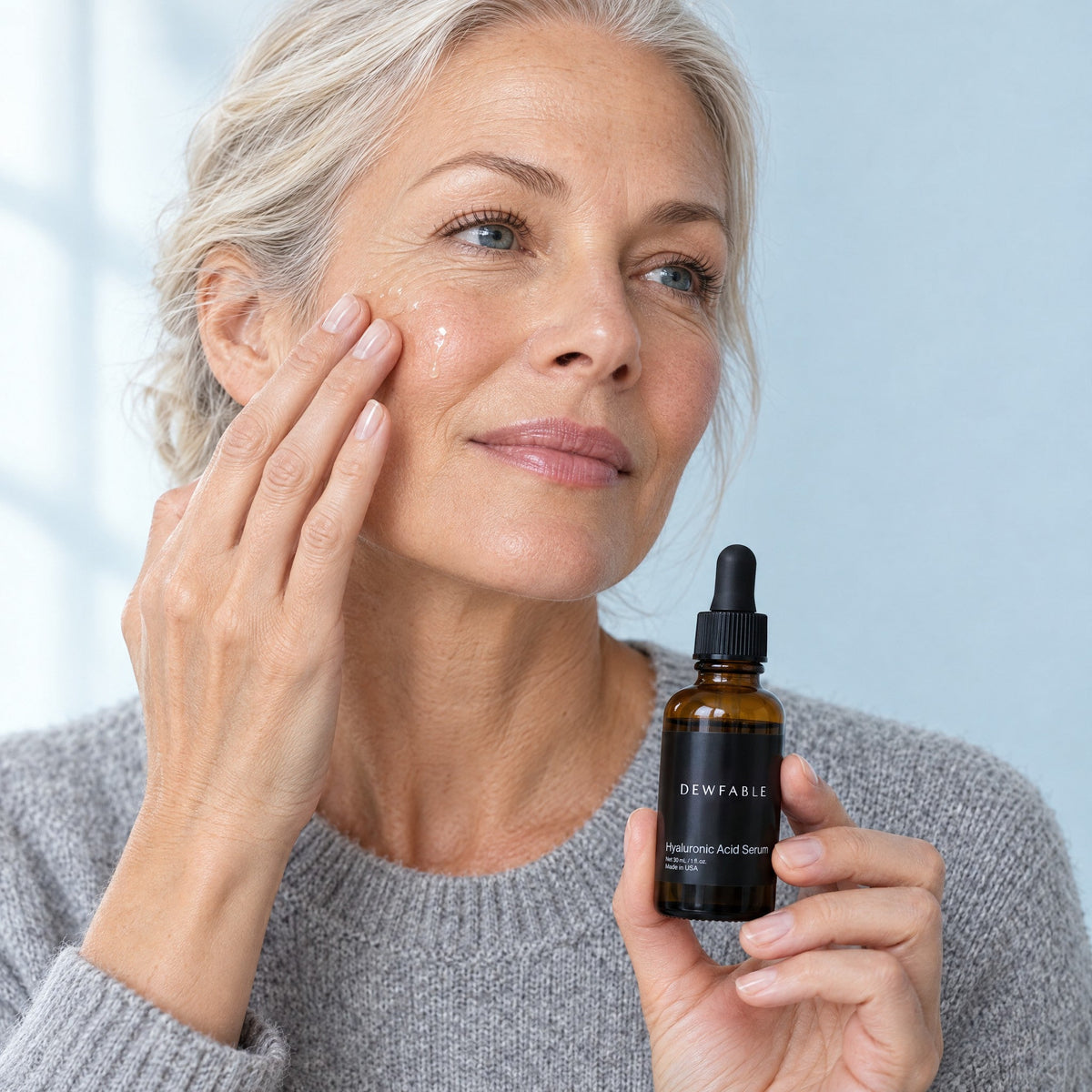 Woman pressing Hyaluronic Acid Serum into her cheek