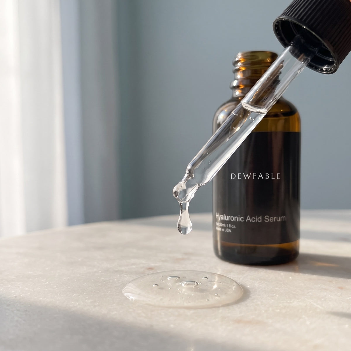A clear drop of Hyaluronic Acid Serum falling from the dropper